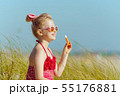 child looking into distance while holding lipstick with spf 55176881
