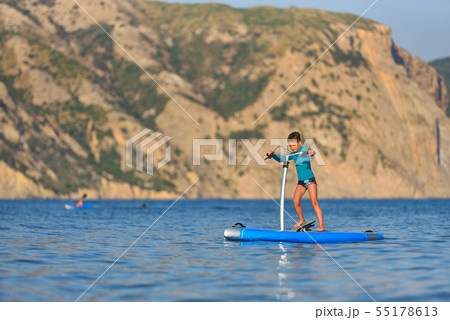 Happy active kid on a Hobie Stand Up Paddle board Happy active kid on a Hobie Stand Up Paddle board 55178613