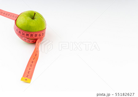 Green apple with red measuring tape. Selective 55182627