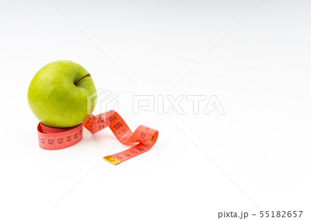 Green apple with red measuring tape. Selective 55182657