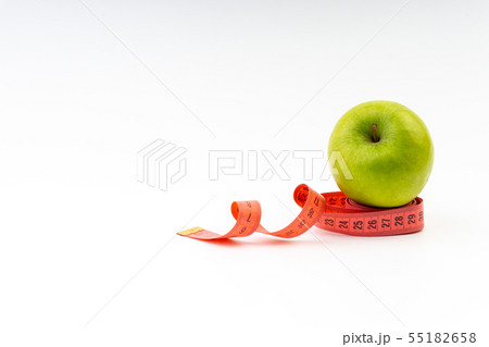 Green apple with red measuring tape. Selective 55182658