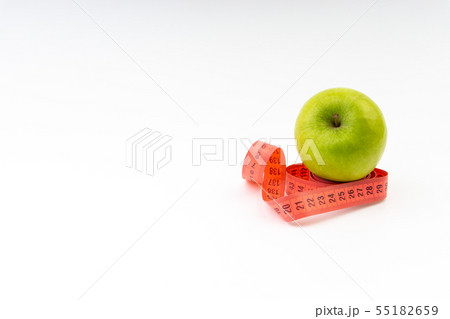 Green apple with red measuring tape. Selective 55182659