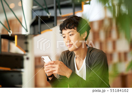 スマホを操作している20代男性 スマホを操作している20代男性 55184102