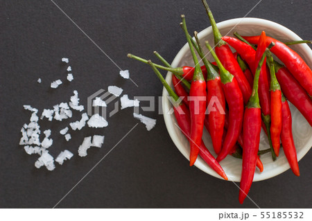 Red hot chili peppers on a green plate with salt Red hot chili peppers on a green plate with salt 55185532