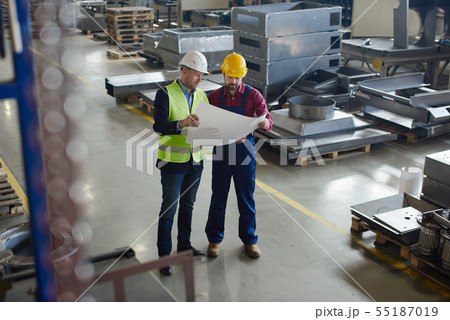 Engineers in hard hats working at the industrial plant. 55187019