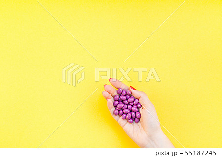 Woman hand holding purple pills handful Woman hand holding purple pills handful 55187245
