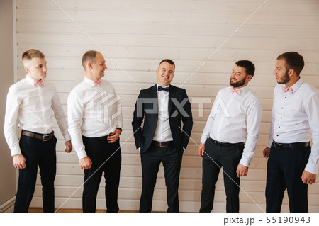 Handsome groom with his groomsman at home. Five man. Groom dressed in suit, gromsmen in white shirt Handsome groom with his groomsman at home. Five man. Groom dressed in suit, gromsmen in white shirt 55190943