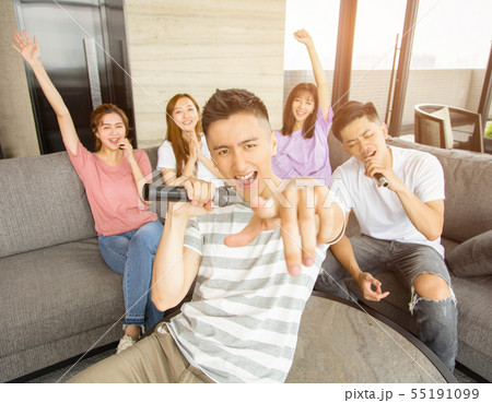 Group of friends playing karaoke at home 55191099
