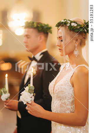 Beautiful couple in church. Newlyweds swear to each other to love forever. Happy bride and groom Beautiful couple in church. Newlyweds swear to each other to love forever. Happy bride and groom 55191263