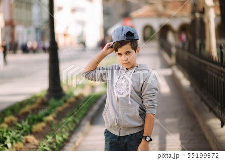 Portrait of little boy in cap. Stylish boy walking in the city Portrait of little boy in cap. Stylish boy walking in the city 55199372