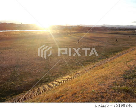 夕方の運動公園 閃光と伸びる影の写真素材