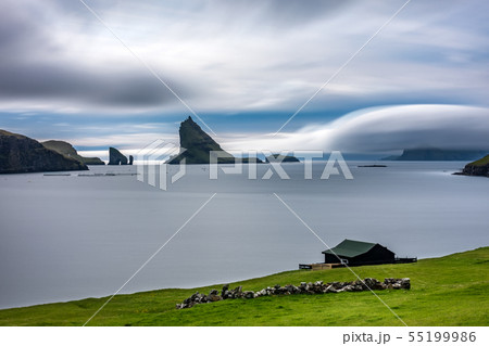 Amazing long exposure of Drangarnir gate, Tindholmur and typical house in Faroe Islands Amazing long exposure of Drangarnir gate, Tindholmur and typical house in Faroe Islands 55199986