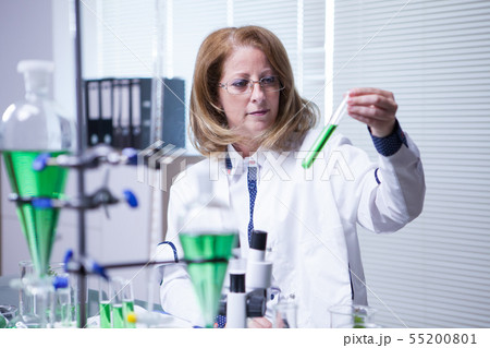 Chemistry scientist holding a test tube with green solution in a research lab 55200801