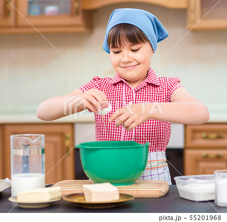 Girl is cooking in kitchen Girl is cooking in kitchen 55201968