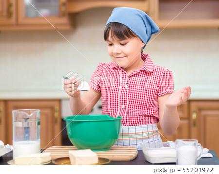 Girl is cooking in kitchen Girl is cooking in kitchen 55201972