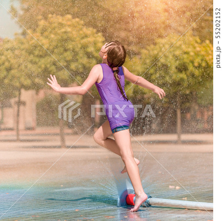 Girl is enjoying fountain with cold water 55202152