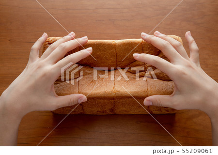 食パンを割る様子 女性手元 55209061