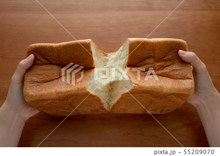 食パンを割る様子 女性手元 55209070
