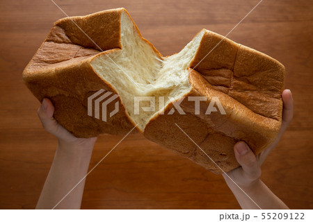 食パンを割る様子 女性手元 55209122