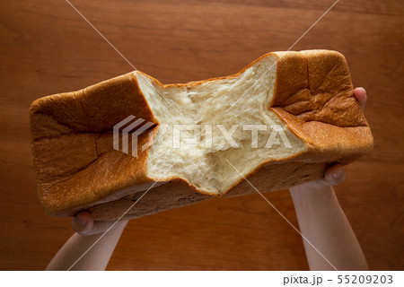 食パンを割る様子 女性手元 55209203