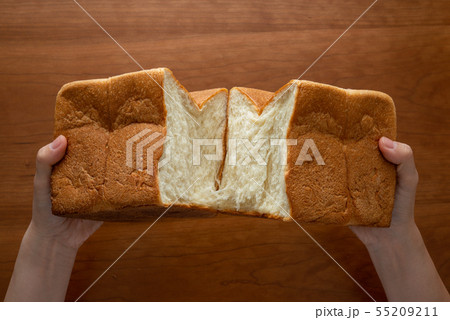 食パンを割る様子 女性手元 55209211