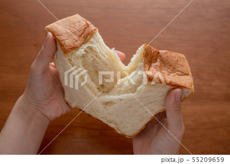 食パンをちぎる様子 女性手元 55209659