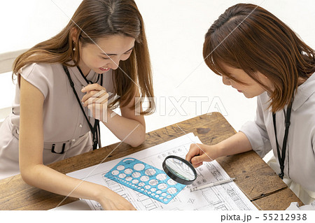 リフォーム工事の現場事務所で図面納まりを確認し仕上げの指示をする設計事務所の一級建築士女性工事監理者 55212938