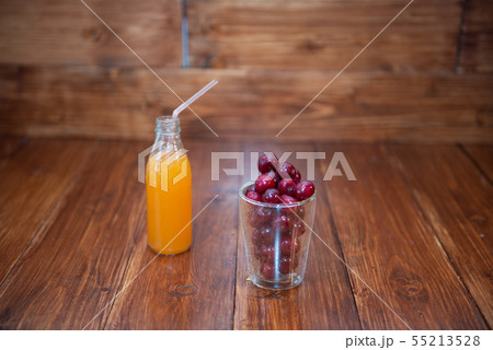 Sweet cherry, black cherries in a glass on wooden background with fresh juicy in glass bottle 55213528