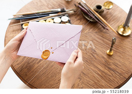 Female hands hold an envelope with a letter and a surgut seal. Gift Certificate. Wedding invitation Female hands hold an envelope with a letter and a surgut seal. Gift Certificate. Wedding invitation 55218039