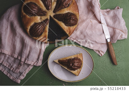 Sliced pear cake on a kitchen towel above view Sliced pear cake on a kitchen towel above view 55218433