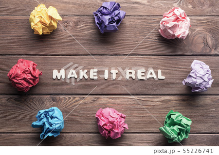 Make it real phrase on wooden table and paperballs around Make it real phrase on wooden table and paperballs around 55226741