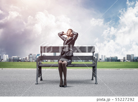 Stressful woman sitting on wooden bench Stressful woman sitting on wooden bench 55227292