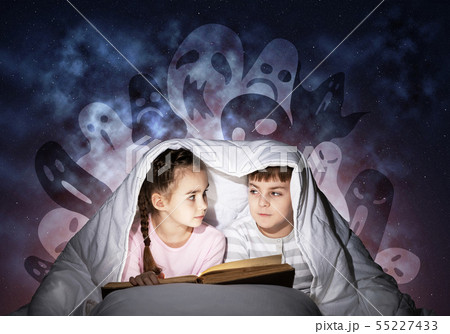Cute girl and boy reading book in bed 55227433