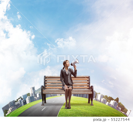 Business woman with megaphone on wooden bench Business woman with megaphone on wooden bench 55227544