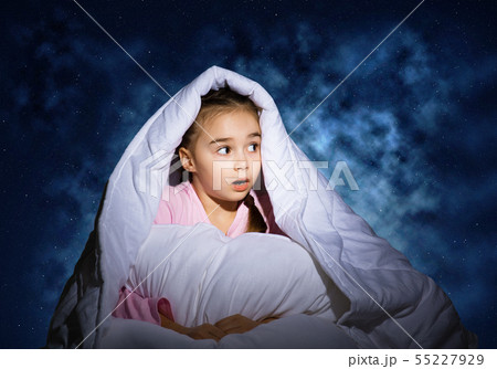 Surprised child hiding under blanket Surprised child hiding under blanket 55227929