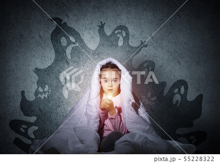 Surprised girl hiding under blanket 55228322