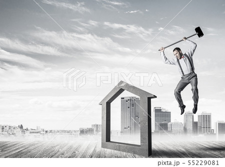 Manager man crashing stone home as symbol for real estate insurance Manager man crashing stone home as symbol for real estate insurance 55229081