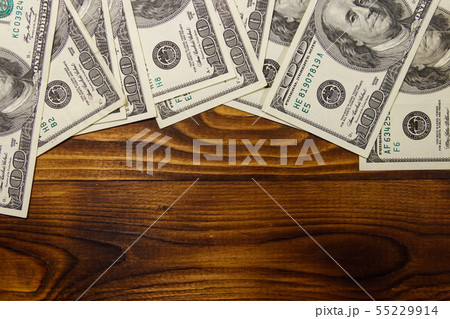 One hundred dollars bills on wooden desk One hundred dollars bills on wooden desk 55229914