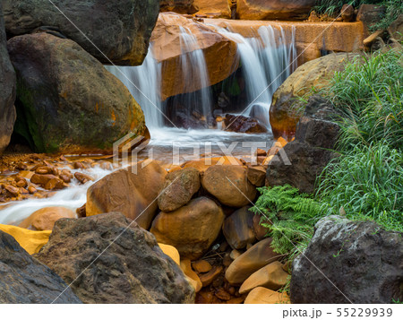 Smooth flowing water falling over rocks Smooth flowing water falling over rocks 55229939