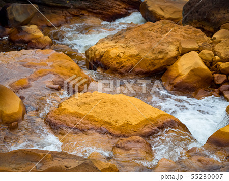 Smooth flowing water falling over rocks Smooth flowing water falling over rocks 55230007