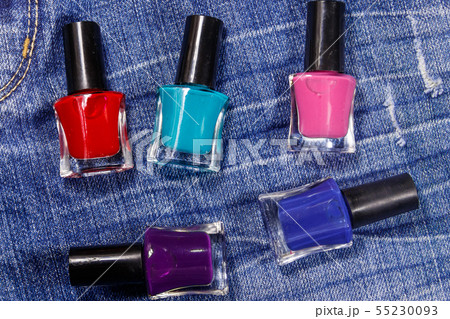 Set of nail polish bottles on jeans background Set of nail polish bottles on jeans background 55230093