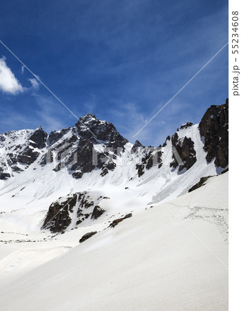 Snowy sunlight mountains and cloudy blue sky Snowy sunlight mountains and cloudy blue sky 55234608