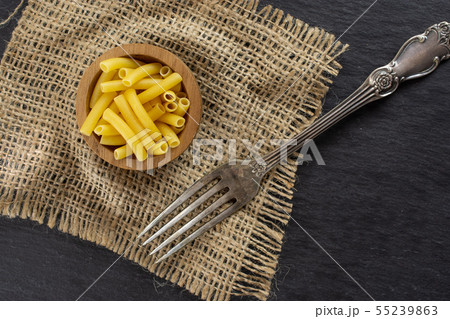 Raw macaroni pasta on grey stone Raw macaroni pasta on grey stone 55239863