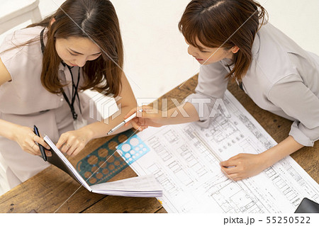 リフォーム工事の現場事務所で図面納まりを確認し仕上げの指示をする設計事務所の一級建築士女性工事監理者 55250522