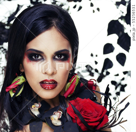 pretty brunette woman with rose jewelry, black and red, bright make up kike a vampire closeup red 55256531