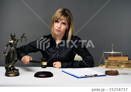 A young fair woman judge works in her office. 55258737