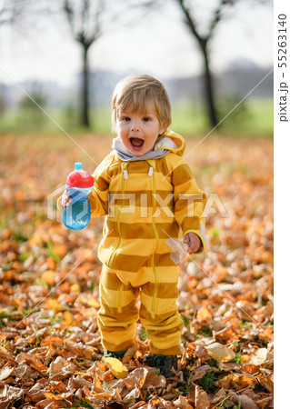 Happy little boy with water bottle playing in the 55263140