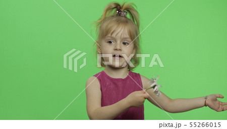 Positive blonde girl in purple dress holds chamomile flower. Chroma Key 55266015
