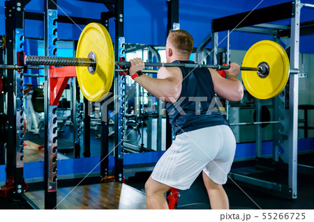 athlete performs barbell squats in the gym 55266725
