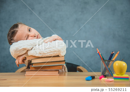 Sleepy schoolgirl doesn't want to study, but the sleep is in her priority. Girl is opening one eye Sleepy schoolgirl doesn't want to study, but the sleep is in her priority. Girl is opening one eye 55269211